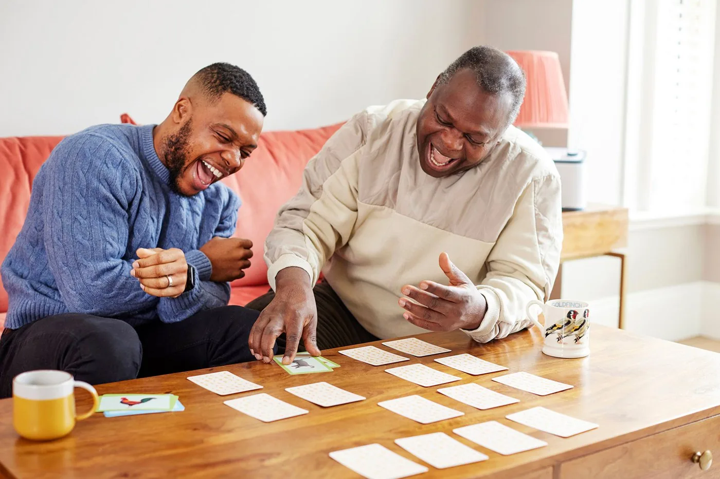 Two men enjoying a Relish activity together on a sofa